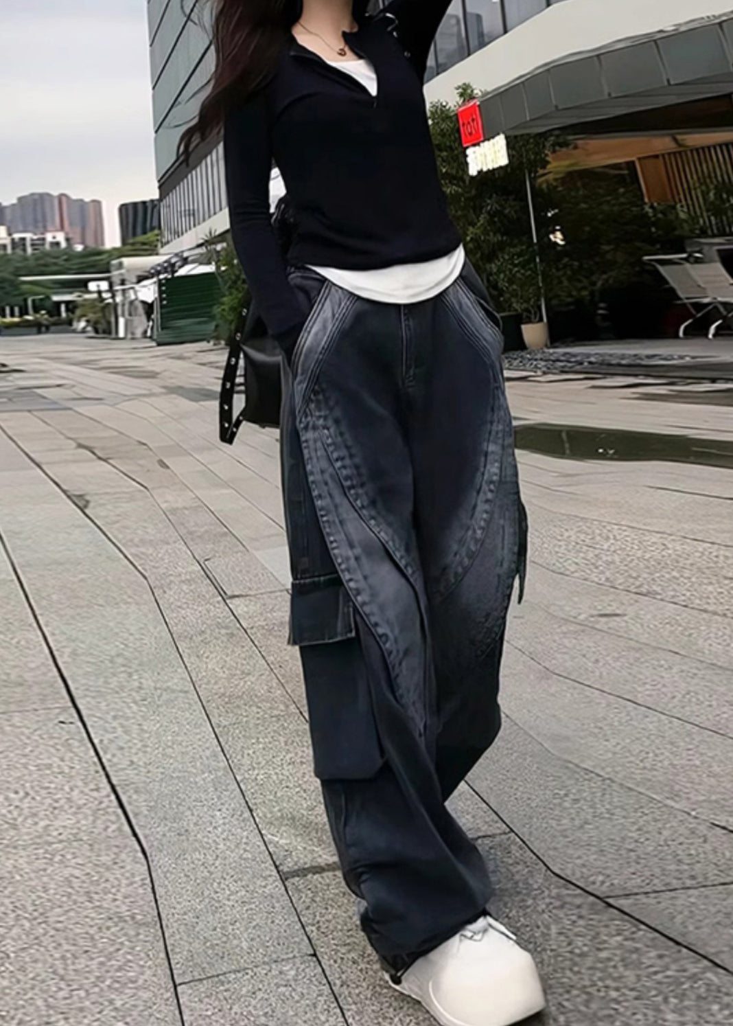 Avec un pantalon en jean noir élégant et des poches surdimensionnées
