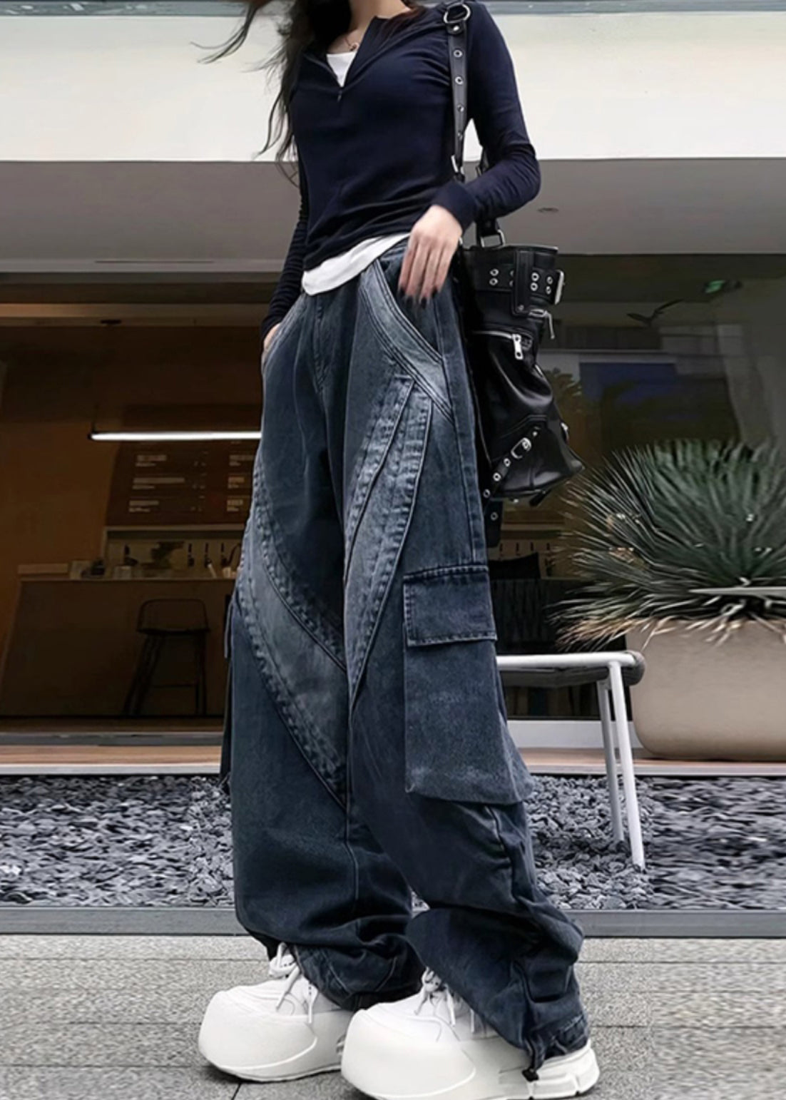 Avec un pantalon en jean noir élégant et des poches surdimensionnées