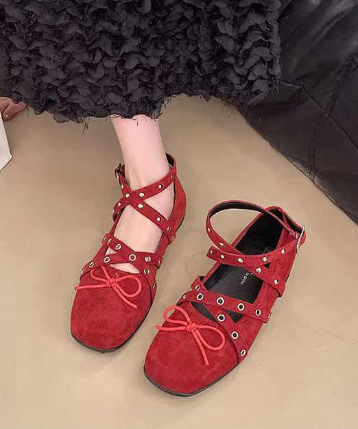 Chaussures à brides plates rouges en daim avec nœud croisé et rivets